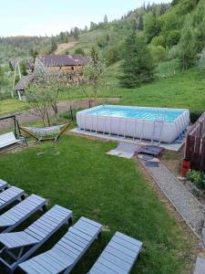 a large swimming pool with lounge chairs in a yard at День і ніч in Slavske