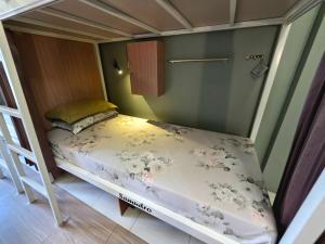 a small bedroom with a bed in a room at Little Malang Hostel小玛瑯青年旅舍 in Malang