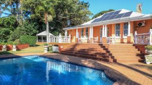 a house with a swimming pool in front of a house at Sica's Guest House in Durban