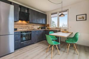 a kitchen with a table and green chairs at An der Haffküste Meerzeit in Zirchow