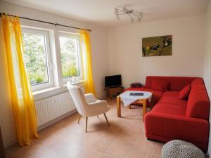 a living room with a red couch and a table at Lindenhof Hahn in Blankenrath