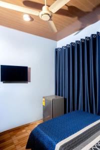 a bedroom with a blue bed and a blue curtain at Aniyak Guest House in Sekondi-Takoradi