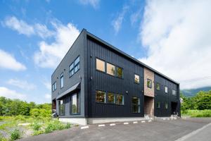 a black house with a lot of windows at Hirafu Tomten in Kutchan
