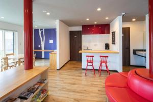 a kitchen and living room with red chairs and a counter at Hirafu Tomten in Kutchan