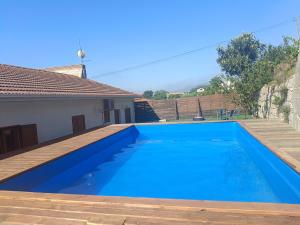 a large blue swimming pool with a wooden deck at Casa do Casal do Douro in Marco de Canaveses