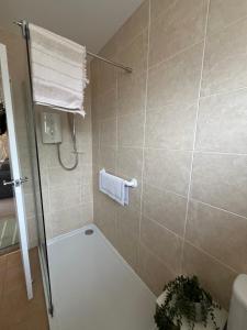 a bathroom with a shower with a toilet and a sink at Westfields Bungalow in Mirfield +12 photos