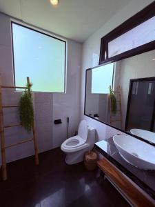 a bathroom with a toilet and a sink and a mirror at Star Fish Cozy House in Ban Nua