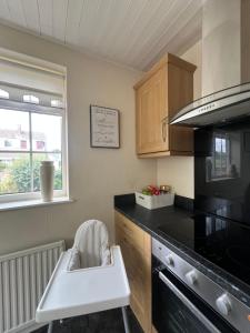 a kitchen with a sink and a stove at Westfields Bungalow in Mirfield