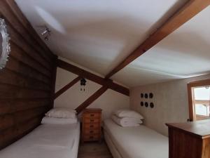 two beds in a room with wooden ceilings at Rimbes Casteljaloux - Gite 6 pers in Casteljaloux +26 photos