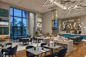 a restaurant with tables and chairs and windows at Sheraton Nice in Nice