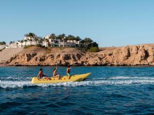 three people on a yellow boat in the water at Movenpick Resort Sharm El Sheikh in Sharm El Sheikh