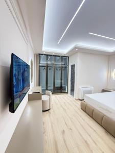 a white bedroom with a bed and a flat screen tv at Old Town Inn in Pogradec +61 photos