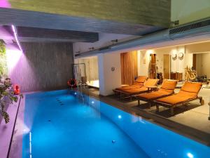 a swimming pool with orange chairs and a swimming pool at COCO-MAT Athens Jumelle in Athens