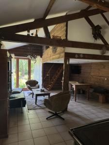 a living room with a vaulted ceiling and a table and chairs at Rimbes Casteljaloux - Gite 6 pers in Casteljaloux