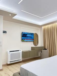 a room with a bed and a tv on a wall at Old Town Inn in Pogradec