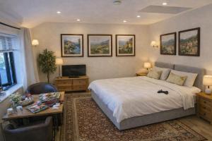 a bedroom with a large bed and a desk with a computer at Langford Apartment and Rooms in Bristol