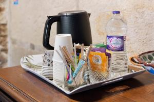 a tray filled with dishes and a bottle of water at B&B La Demoiselle in Aignay-le-Duc