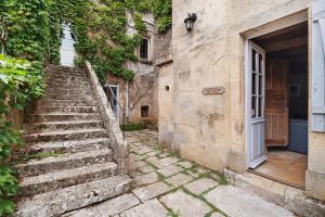 an old stone building with stairs next to a door at B&B La Demoiselle in Aignay-le-Duc