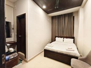 a small bedroom with a bed and a chair at The Core in Kohīma