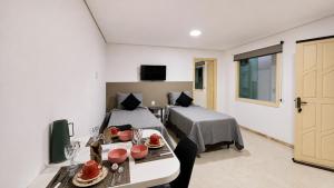 a room with a bed and a table and a bed and a room at Villa Sunset in Arraial d'Ajuda