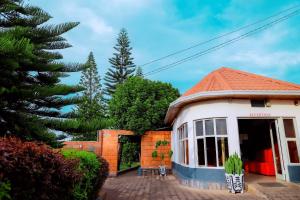 a house with a palm tree in front of it at Martin Aviator Hotel in Kigali