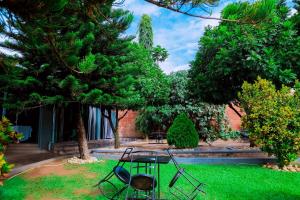 a garden with a table and chairs in the grass at Martin Aviator Hotel in Kigali