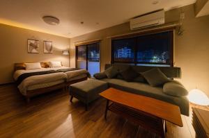 a bedroom with a bed and a couch and a window at fleuve tenmonkan in Yamashitachō
