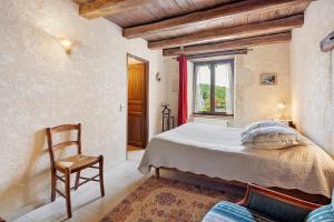 a bedroom with a bed and a chair and a window at B&B La Demoiselle in Aignay-le-Duc