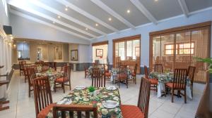 a restaurant with tables and chairs in a room at Sica's Guest House in Durban