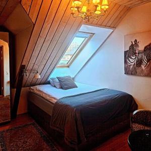 a attic bedroom with a bed with a window at Hotell & Spa Lögnäs Gård in Laholm