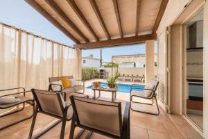 a patio with chairs and a table and a pool at Ca S'Ingles in Alcudia