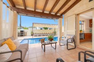a patio with a couch and a table next to a pool at Ca S'Ingles in Alcudia +42 photos