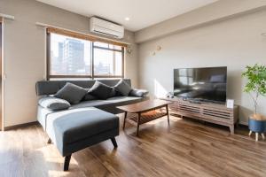a living room with a couch and a flat screen tv at fleuve tenmonkan in Yamashitachō