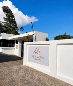 a sign in front of a white building at The Spear Guest Lodge in Graskop
