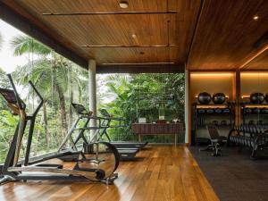 a gym with a treadmill and a table and chairs at V Villas Phuket - MGallery Collection in Panwa Beach