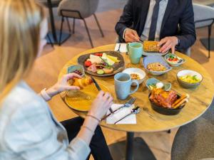two people sitting at a table eating food at ibis Duesseldorf Airport in Düsseldorf +88 photos