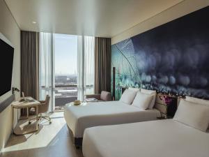 a hotel room with two beds and a large window at Novotel Mexico City Toreo in Mexico City