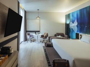 a room with a bed and a desk and a table at Novotel Mexico City Toreo in Mexico City +119 photos