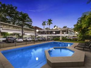 a swimming pool in front of a building with a parking lot at Mercure Rockhampton in Rockhampton
