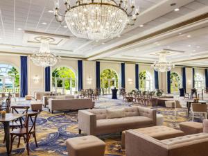 a hotel lobby with couches and tables and chandeliers at Fairmont El San Juan Hotel in San Juan