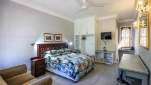 a bedroom with a bed and a tv in it at Sica's Guest House in Durban