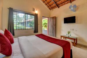 a bedroom with a large bed and a window at Orange Vista Resort Coorg in Kushālnagar +51 photos