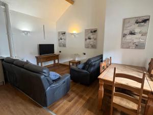 a living room with a couch and a table at Woodside Cottage in Newtown