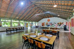 a dining hall with wooden tables and chairs at Orange Vista Resort Coorg in Kushālnagar