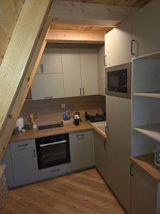 a small kitchen with white cabinets and a staircase at durmitor's golden peace in Šavnik +12 photos
