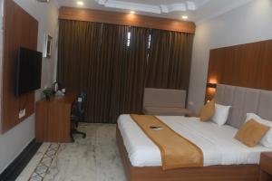 a hotel room with a large bed and a television at Hotel gardenia inn in Gwalior