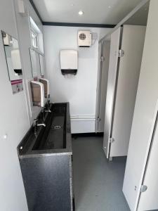 a small bathroom with a sink and a mirror at Festival Glamping At The Drum - Glamping Village in Edinburgh