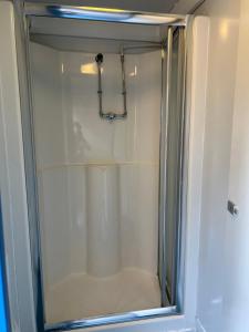 a shower with a glass door in a bathroom at Festival Glamping At The Drum - Glamping Village in Edinburgh +21 photos