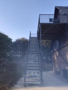 a flight of stairs leading up to a bridge at Logement à la ferme in Bréauté