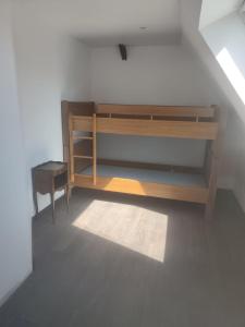 a room with a wooden book shelf and a chair at Logement à la ferme in Bréauté